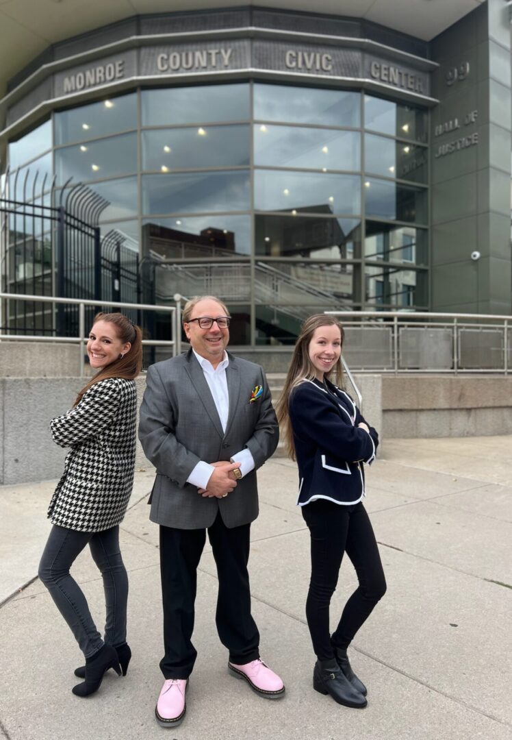 Three people standing in front of a building